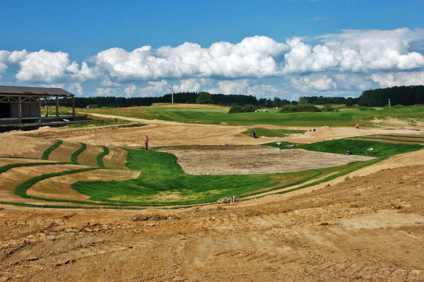 Budowa greenu golfowego: 3. Finalne kształtowanie i uprawa warstwy wegetacyjnej na green approaches, darniowanie pochyłości zapobiegające erozji wodnej.